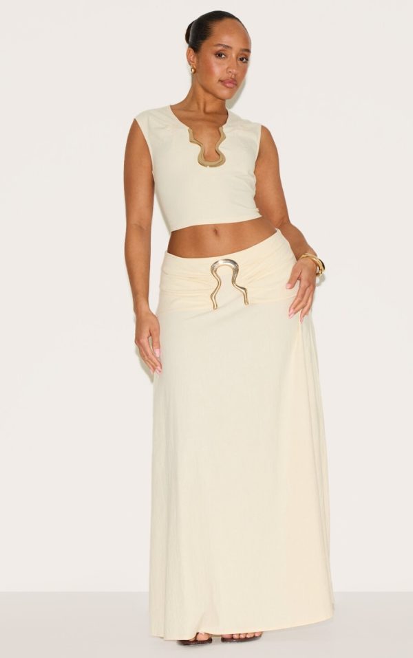 1627d83f48f71333f22a76892890f67334253970_CNM6337_1_shape_cream_linen_fold_gold_wave_trim_maxi_skirt