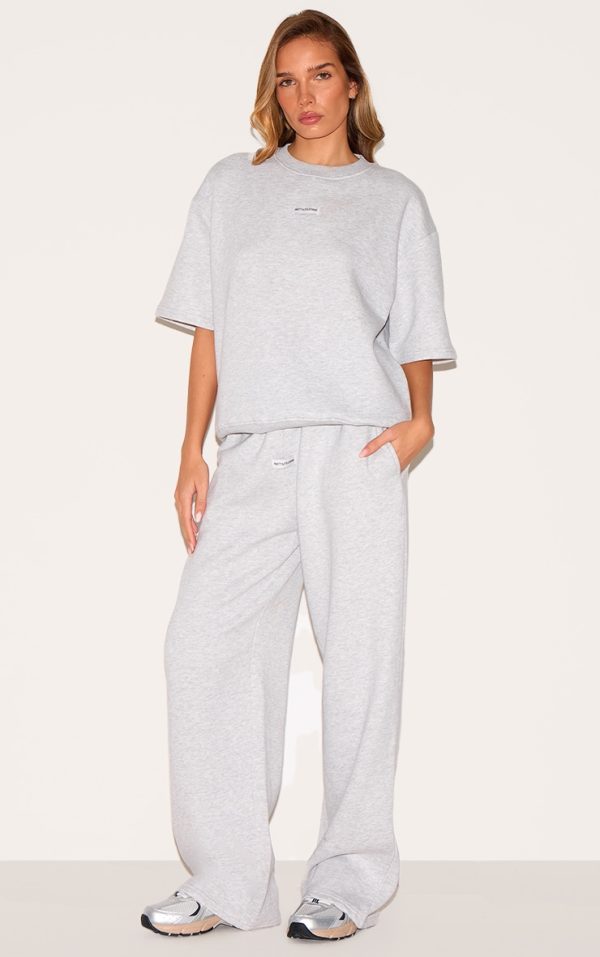 2109b2dec1f05378276fbabc147bdceac6fc9bd6_CNJ5144_3_prettylittlething_ash_grey_badge_detail_oversized_short_sleeve_sweatshirt-1