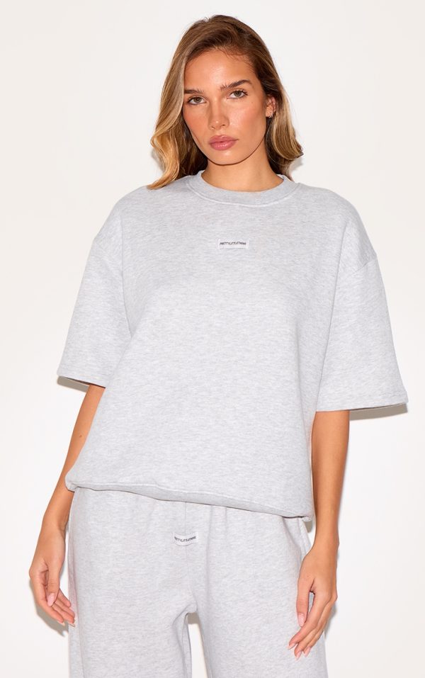 2d32ab5ef99cc78557850eea801743f3758dfa40_CNJ5144_1_prettylittlething_ash_grey_badge_detail_oversized_short_sleeve_sweatshirt-1