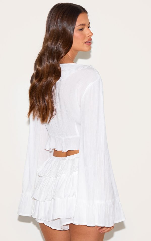 3570997942bcabe8abdf9f7aabc55e72227aff81_CNM3231_2_white_cheesecloth_ruffle_tie_front_long_sleeve_top