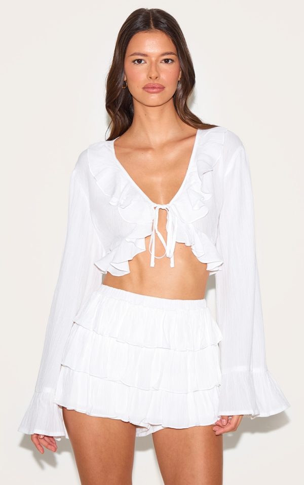 3f0c00f2fa27825a6ff530447abf3fcd01295f2f_CNM3231_1_white_cheesecloth_ruffle_tie_front_long_sleeve_top