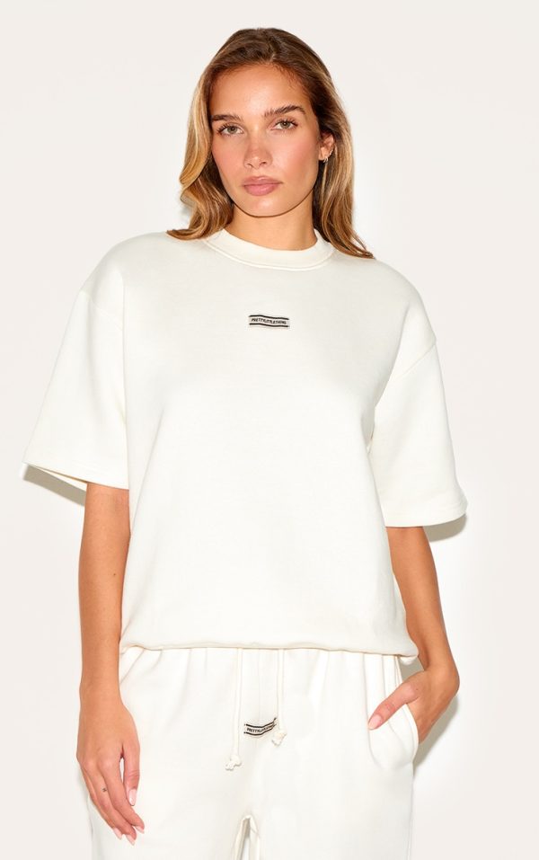 4530017099f8f936309786d812f5199809de34a3_CNI1468_1_prettylittlething_cream_badge_detail_oversized_short_sleeve_sweatshirt