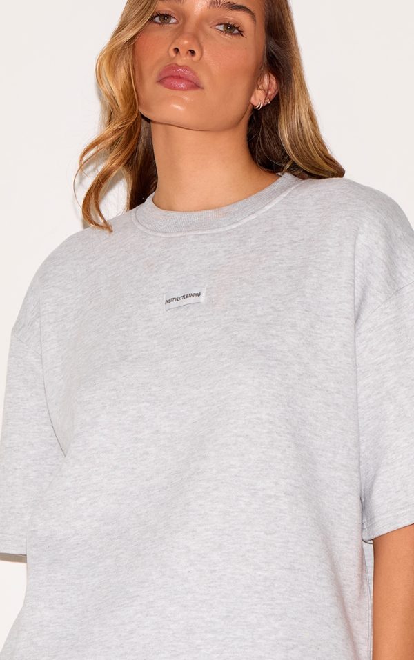 976103d20a72ea43506d37ee0d6330d1164f0dc2_CNJ5144_4_prettylittlething_ash_grey_badge_detail_oversized_short_sleeve_sweatshirt-1