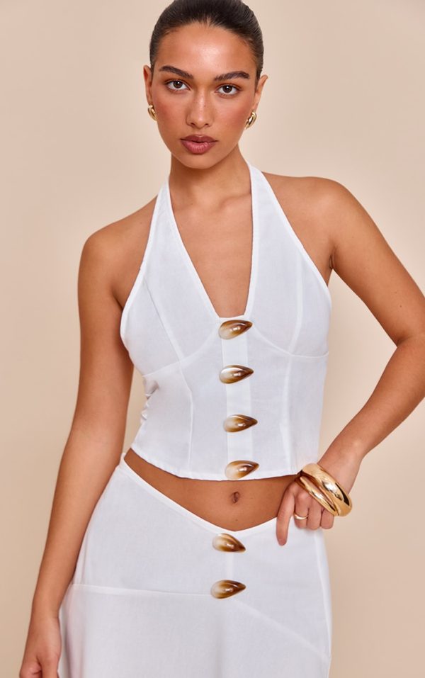 9e3fe14bed9da01b456bbaf3dfea6afbe6b4ea42_CNM8779_1_white_woven_halterneck_button_detail_top