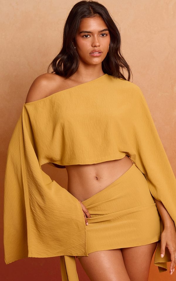 9f5194812eda62e8cf612b5f85722745c3bd97a4_CNM7677_1_deep_mustard_floaty_woven_slash_neck_long_sleeve_top