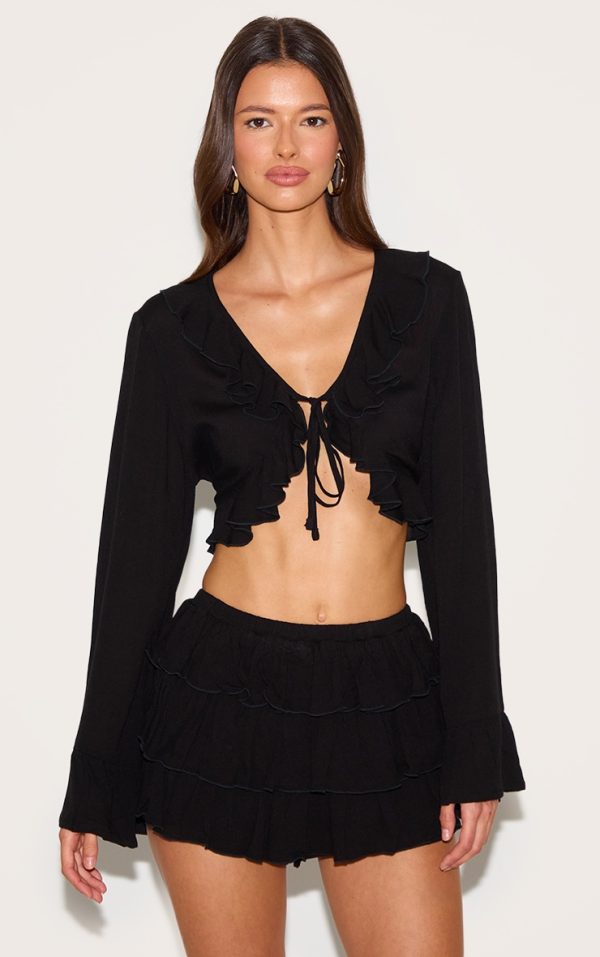 c1767929efda2217fe3c0f5d5c34da03b7356b12_CNM3228_1_black_cheesecloth_ruffle_tie_front_long_sleeve_top