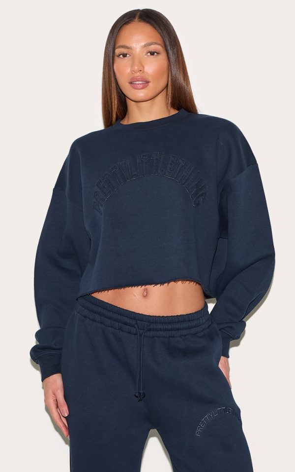 d37c4803778a2a5718f03174e64ab80baf2d2e47_CNM2679_1_tall_navy_distressed_detail_varsity_cropped_sweatshirt
